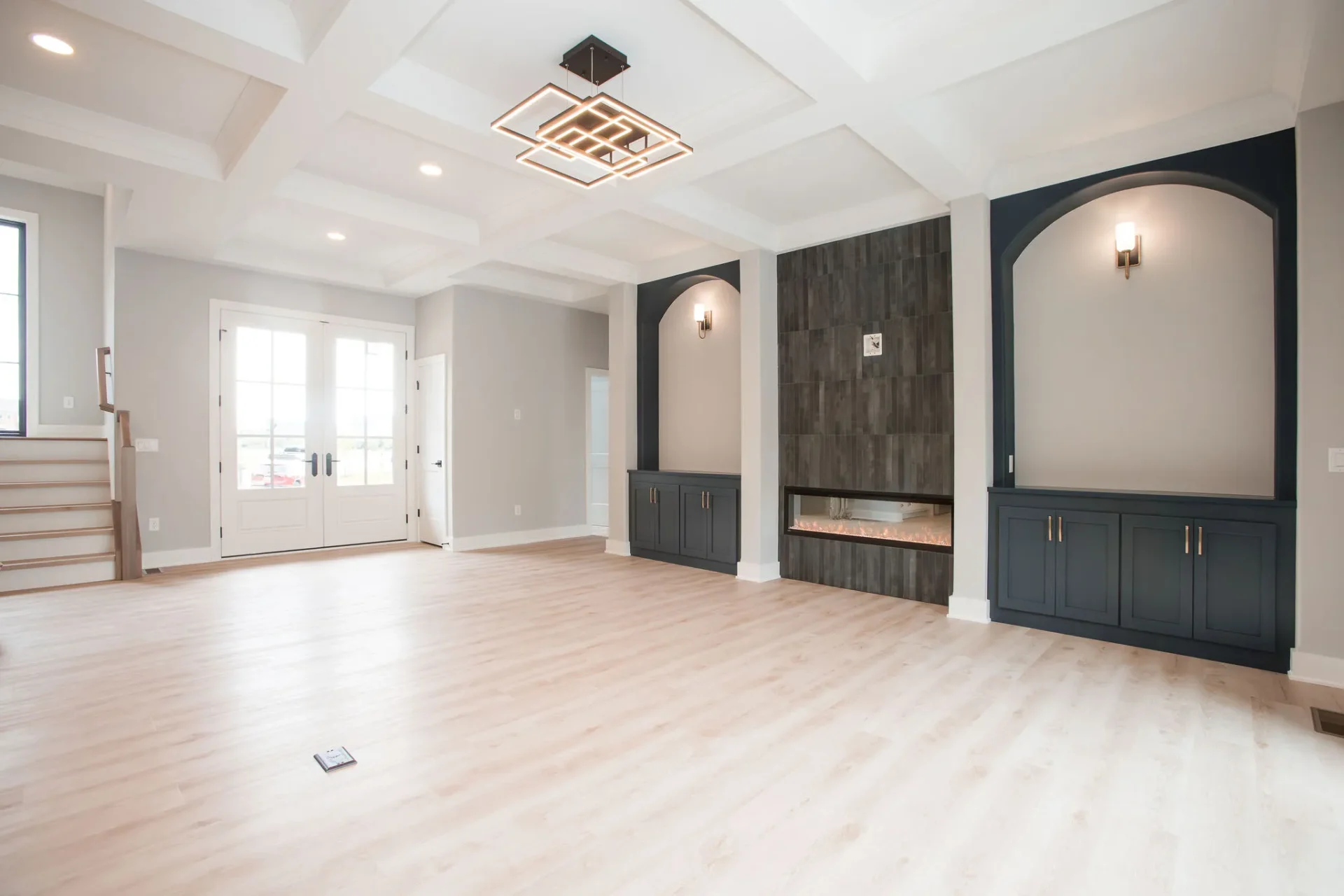 Spacious modern living room with coffered ceiling and fireplace.