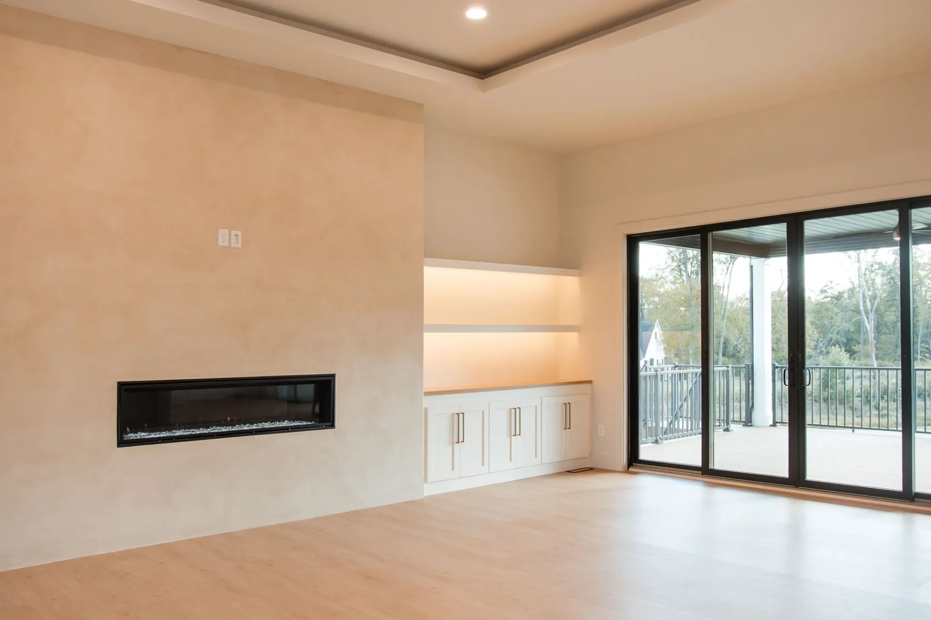Modern living room with a linear fireplace and large sliding glass doors.